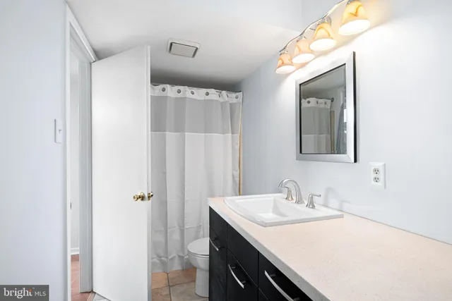 a bathroom with a sink vanity granite and a mirror