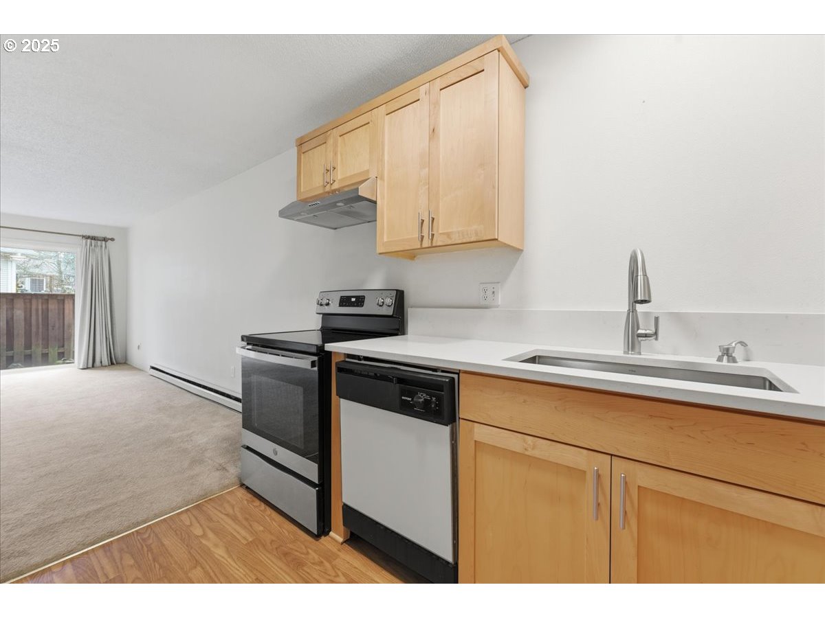 6835 Southwest Capitol Hill Road, Unit 30 Portland, OR 97219 - Photo 12 of 33 a kitchen with a sink cabinets and stainless steel appliances