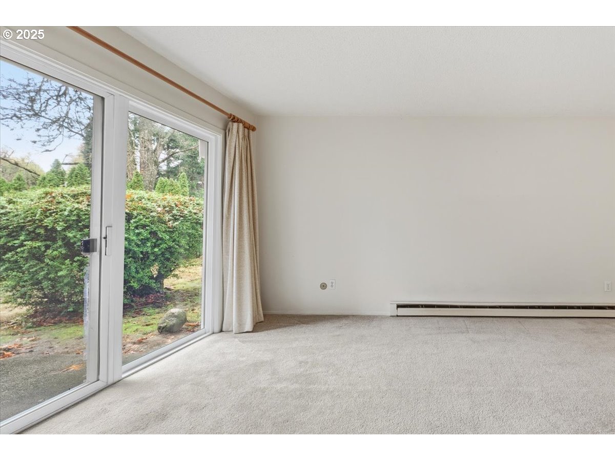 6835 Southwest Capitol Hill Road, Unit 30 Portland, OR 97219 - Photo 14 of 33 a view of an empty room with wooden floor and a window
