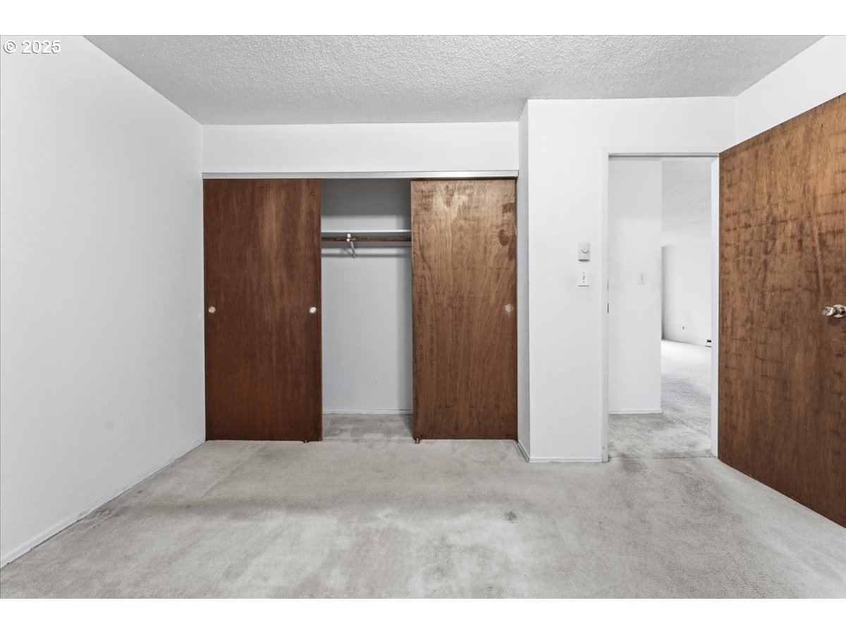 6835 Southwest Capitol Hill Road, Unit 30 Portland, OR 97219 - Photo 19 of 33 a view of an empty room with closet and wooden floor
