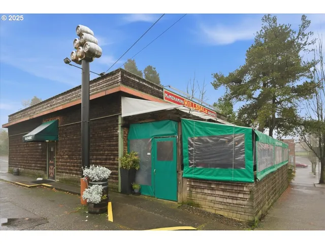 a backyard of a house with table and chairs and wooden fence