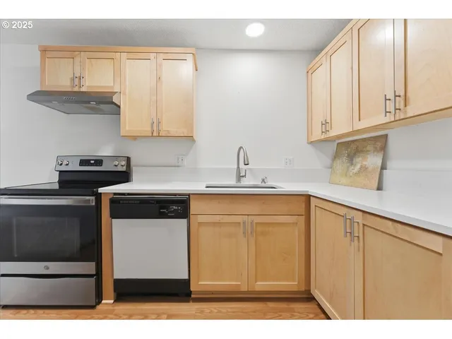 a kitchen with stainless steel appliances granite countertop a sink stove and cabinets