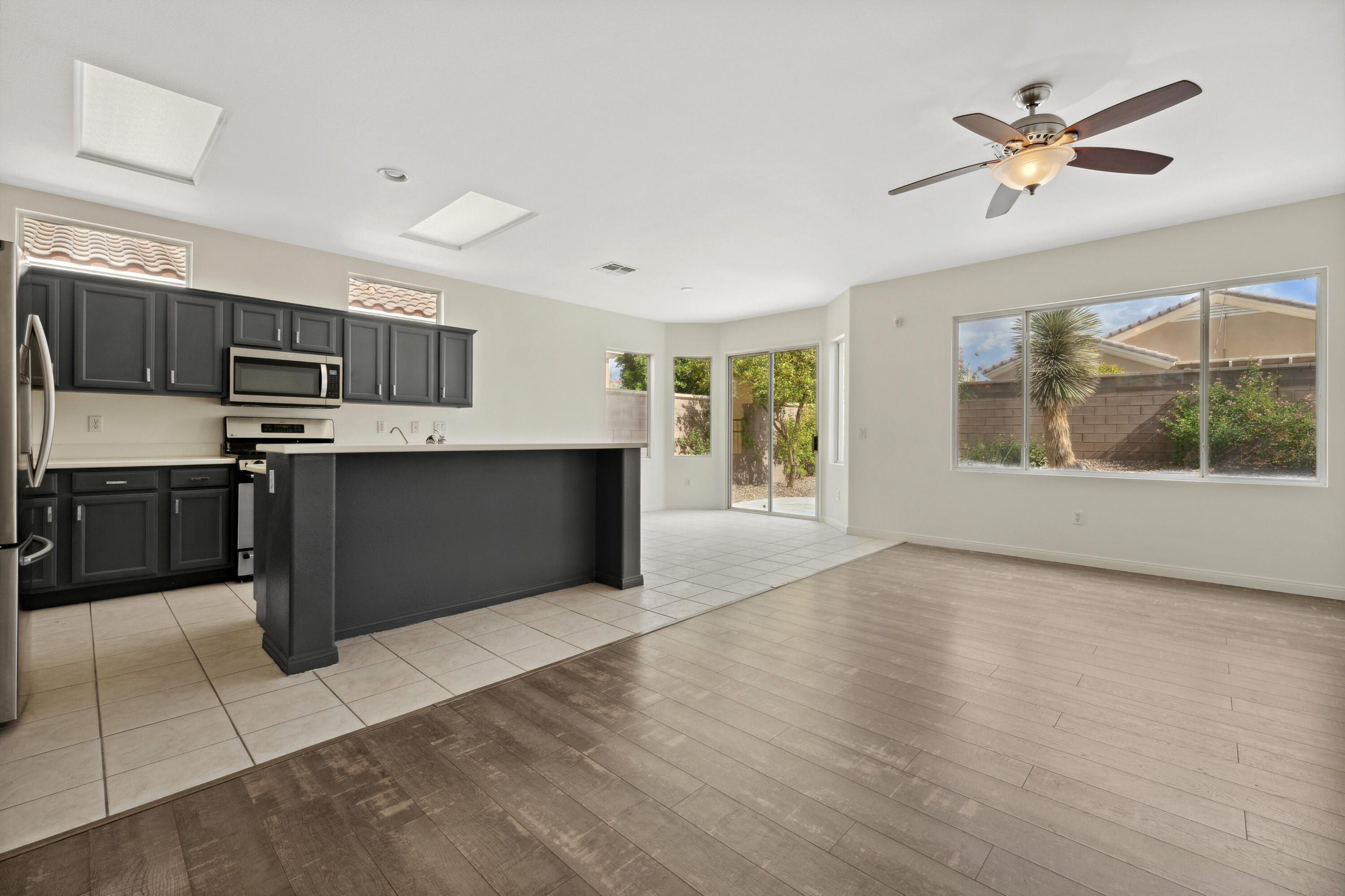 78640 Rainswept Way Palm Desert, CA 92211 - Photo 14 of 37 a kitchen with stainless steel appliances granite countertop a stove top oven a sink with a dining table and chairs