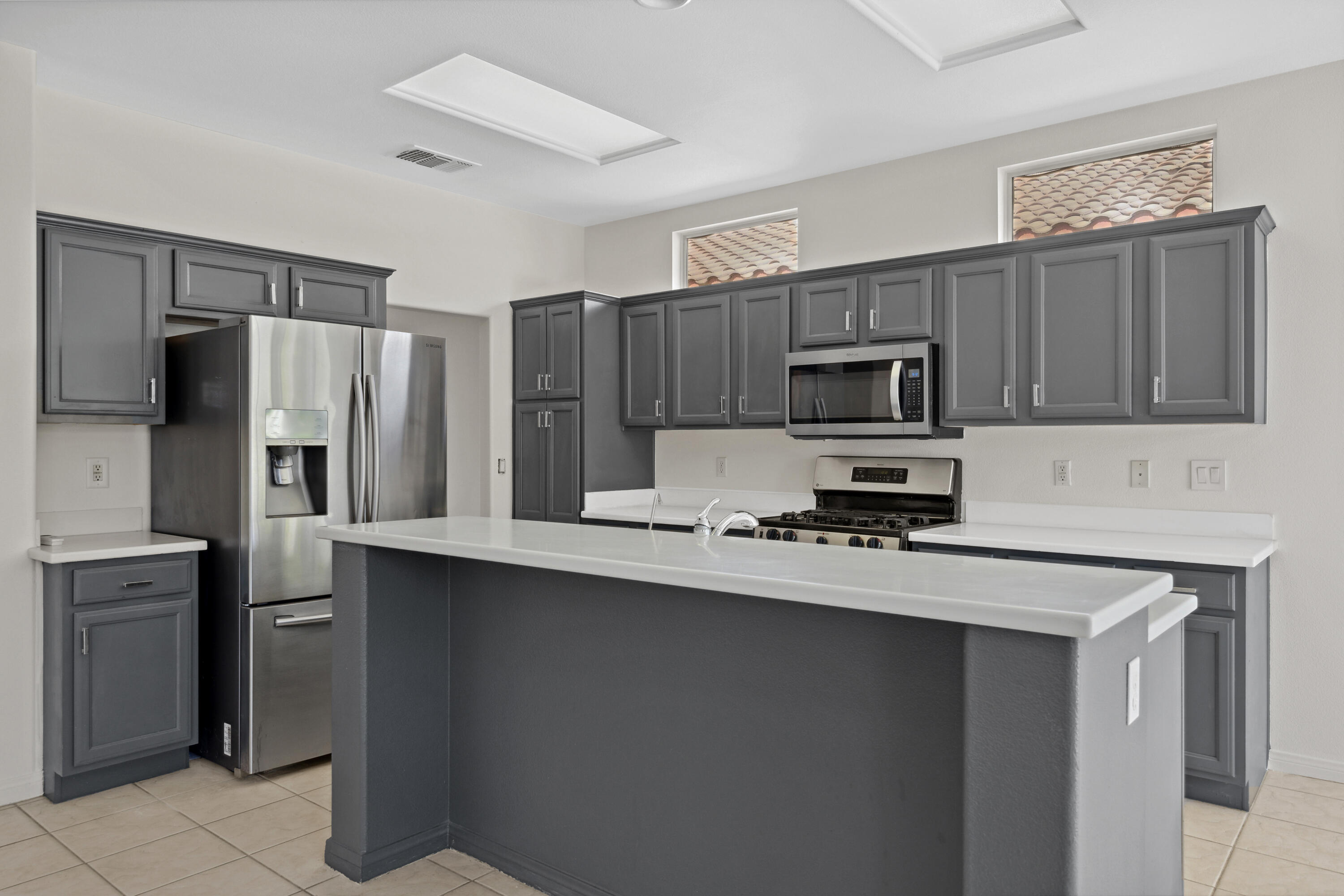 78640 Rainswept Way Palm Desert, CA 92211 - Photo 7 of 37 a kitchen with stainless steel appliances a sink a stove a refrigerator a microwave and cabinets