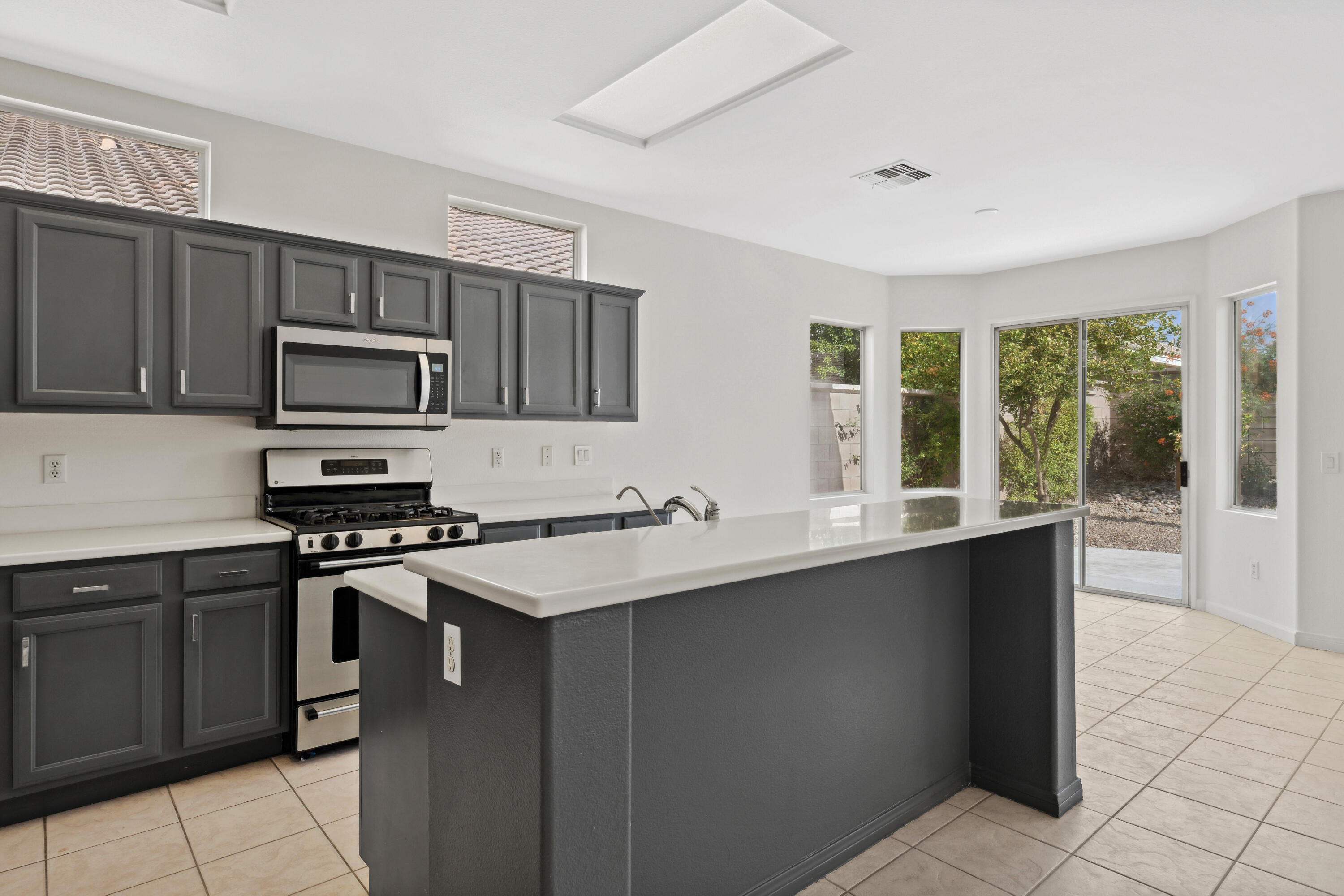 78640 Rainswept Way Palm Desert, CA 92211 - Photo 8 of 37 a kitchen with stainless steel appliances a stove sink microwave and refrigerator