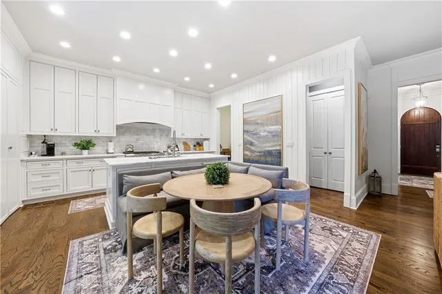 a kitchen with stainless steel appliances granite countertop a stove a sink and white cabinets