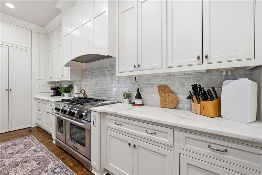 1295 Cumberland Road Northeast Atlanta, GA 30306 - Photo 33 of 71 a kitchen with stainless steel appliances granite countertop white cabinets and a stove