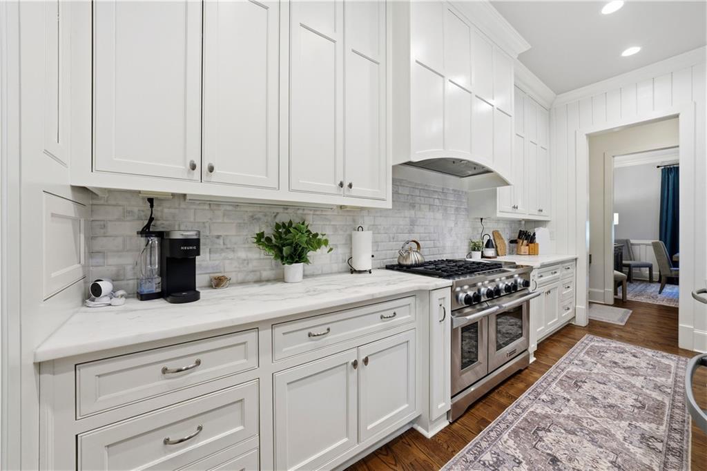 1295 Cumberland Road Northeast Atlanta, GA 30306 - Photo 35 of 71 a kitchen with stainless steel appliances granite countertop a stove a sink and white cabinets