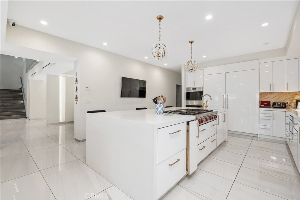 22 Round Up Road Bell Canyon, CA 91307 - Photo 11 of 39 a large kitchen with stainless steel appliances a stove a refrigerator a oven and white cabinets