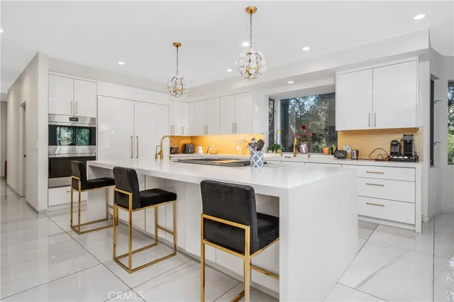 a kitchen with granite countertop white cabinets and stainless steel appliances