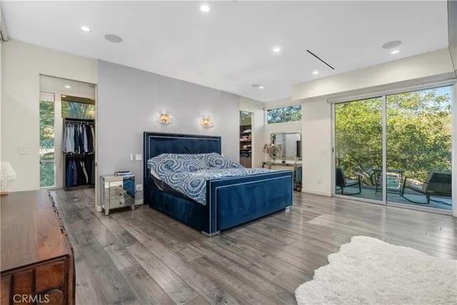 a bedroom with a bed and large windows