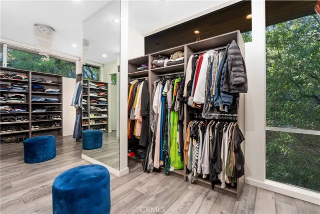 a view of walk in closet with clothes and shoes