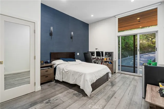 a bedroom with a bed and wooden floor