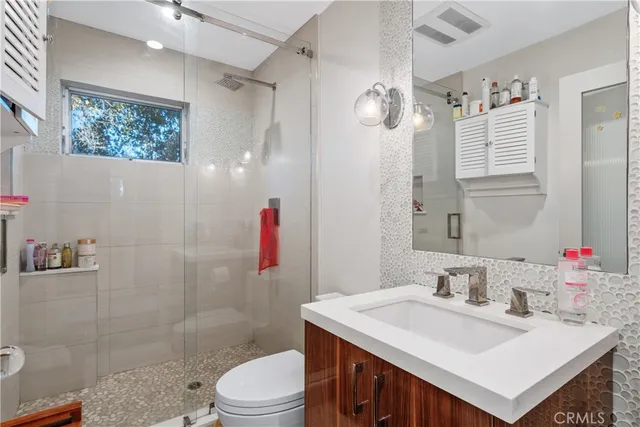a bathroom with a sink vanity mirror and toilet