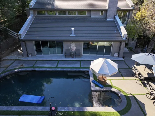 a front view of a house with swimming pool and sitting area