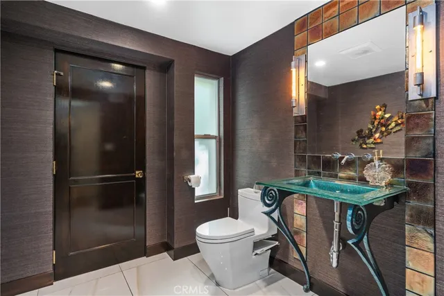 a bathroom with a toilet a sink and mirror