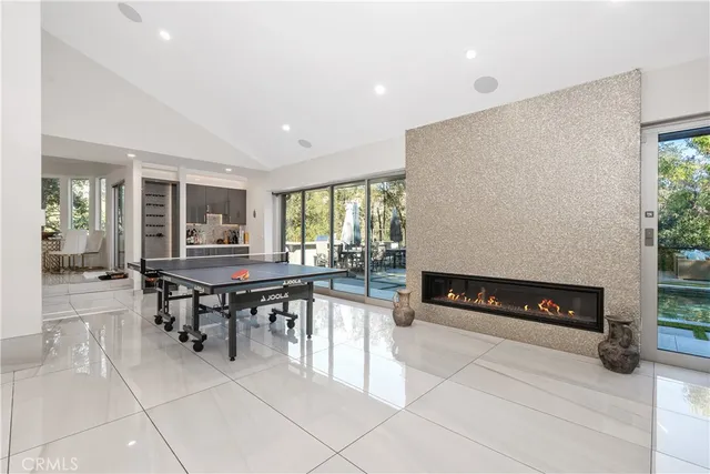a kitchen with stainless steel appliances granite countertop table chairs and a fireplace