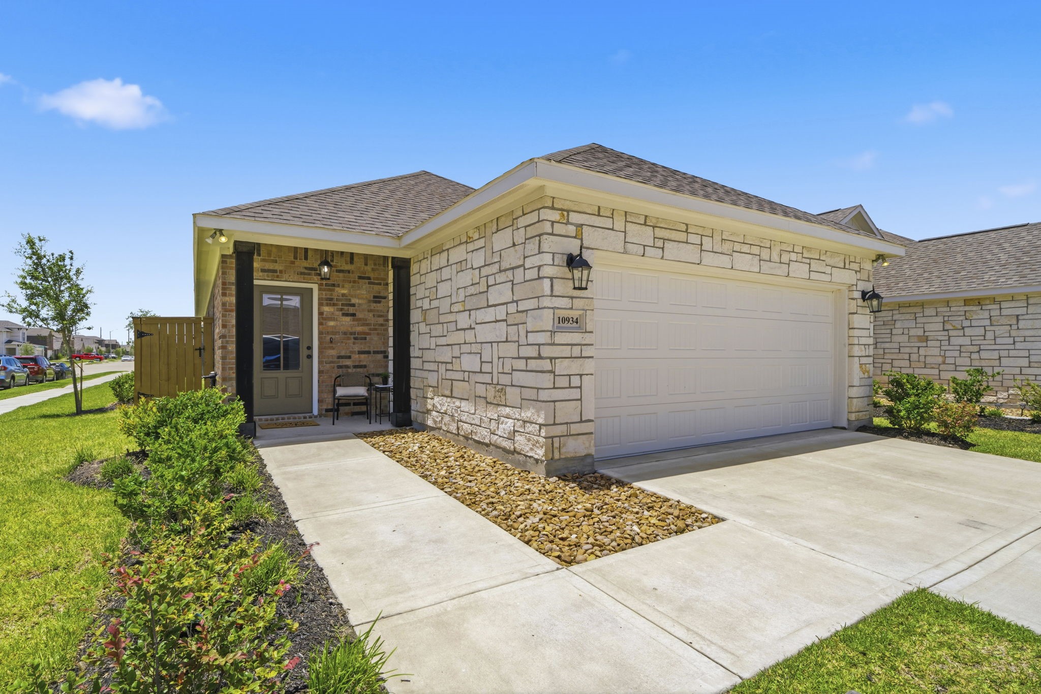 10934 Bonfire Trail Beasley, TX 77417 - Photo 2 of 32 Beautiful stone-and-brick exterior with professional landscaping, a covered front porch, oversized two-car garage, and charming curb appeal, ideally situated on a spacious corner lot in the sought-after master-planned community of Emberly