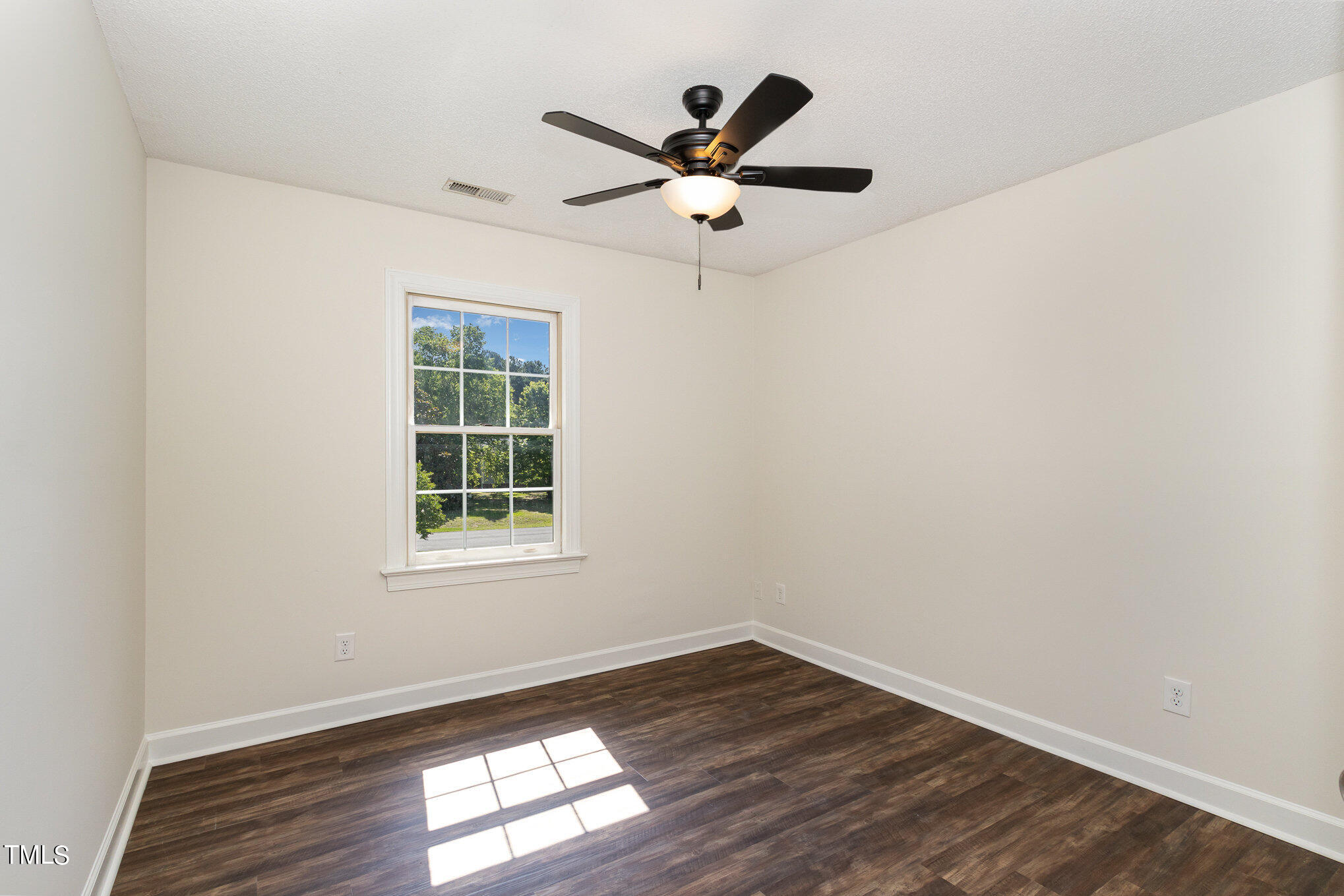 6004 Swales Way Raleigh, NC 27603 - Photo 14 of 24 an empty room with wooden floor a ceiling fan and windows