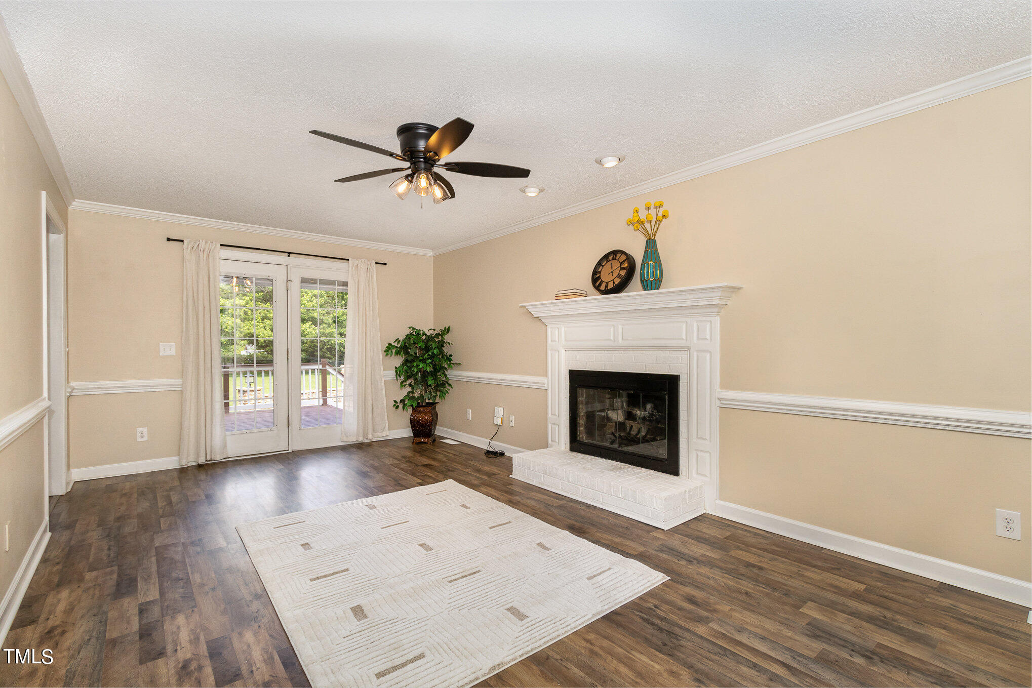 6004 Swales Way Raleigh, NC 27603 - Photo 6 of 24 a view of a livingroom with wooden floor a fireplace and windows