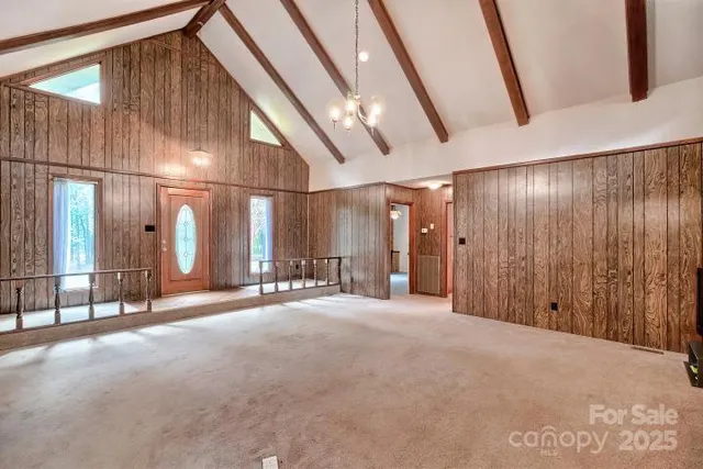 a view of a livingroom with fireplace and kitchen view