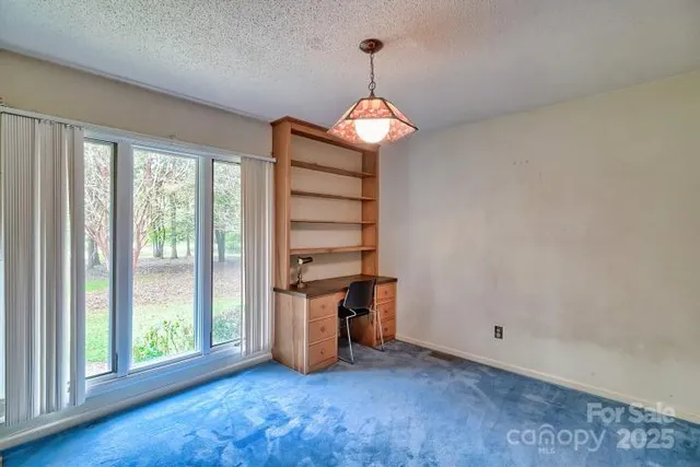 an empty room with wooden floor and hallway