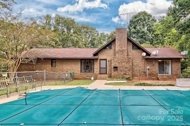 a view of a house with swimming pool and sitting area