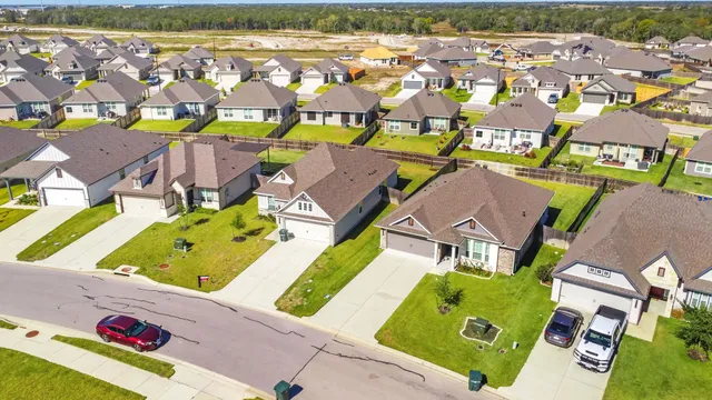 an aerial view of residential houses with outdoor space and swimming pool