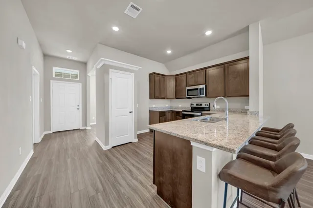 a kitchen with a sink microwave and cabinets