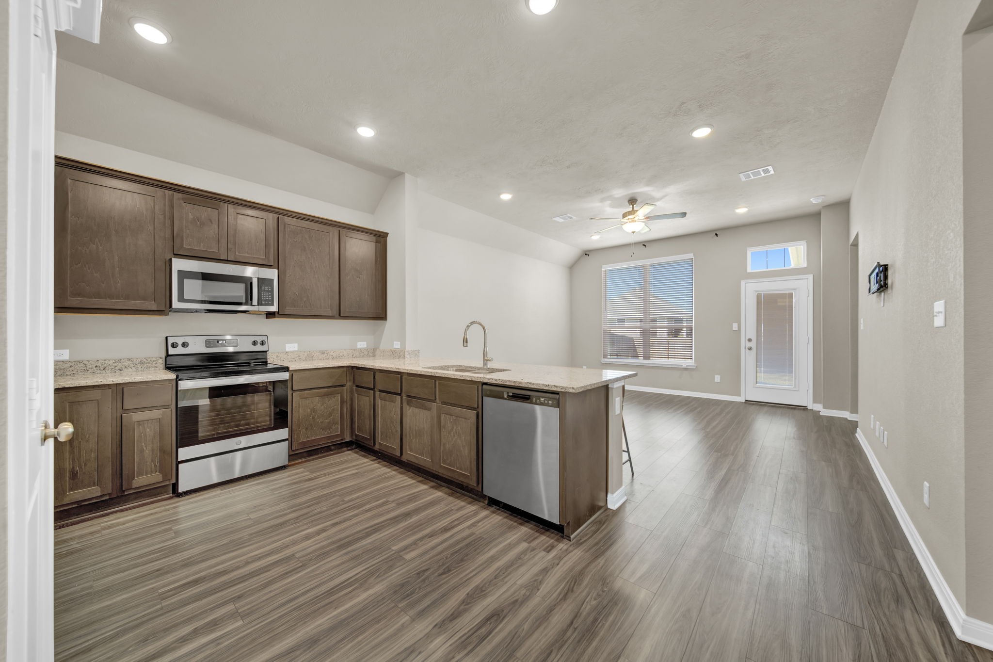 4791 Native Tree Lane Bryan, TX 77845 - Photo 8 of 22 a large kitchen with stainless steel appliances granite countertop a large counter top a stove a sink cabinets and a wooden floor