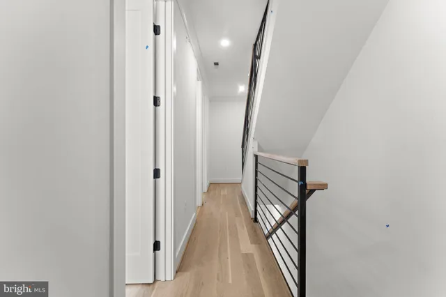 a view of a hallway with wooden floor and staircase