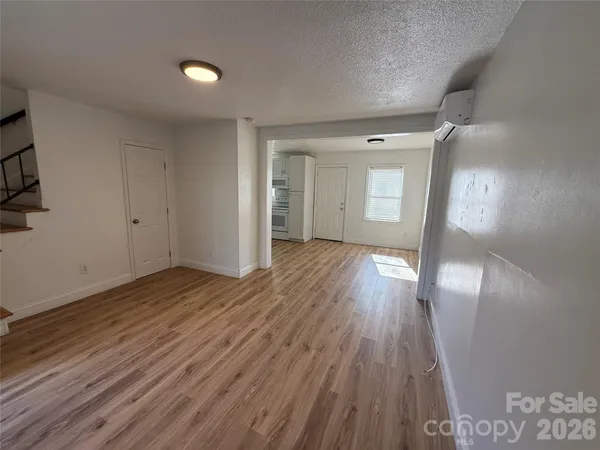 a view of a kitchen with a sink stove cabinets and empty room