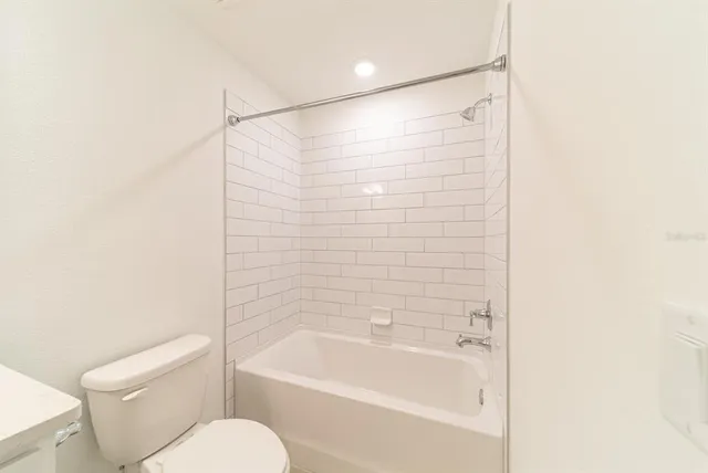 a bathroom with a shower a toilet and a bathtub