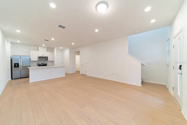 a view of a kitchen with a refrigerator and a stove top oven