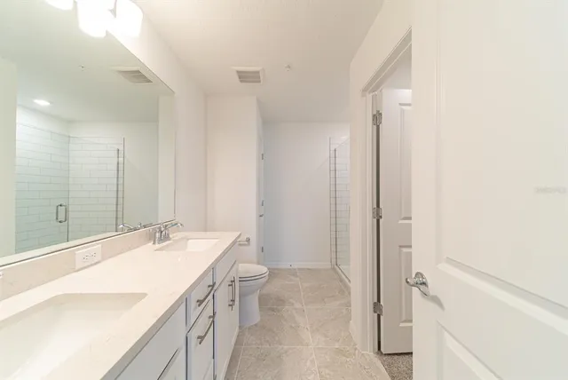 a bathroom with a granite countertop sink toilet and shower