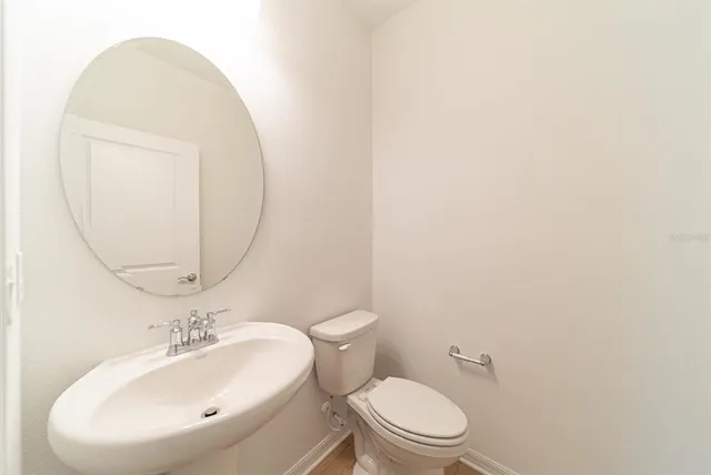 a white toilet sitting next to a bathroom sink