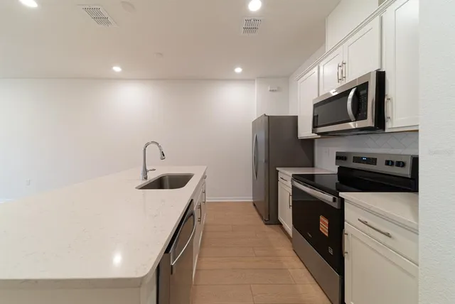 a kitchen with stainless steel appliances granite countertop a sink and a microwave