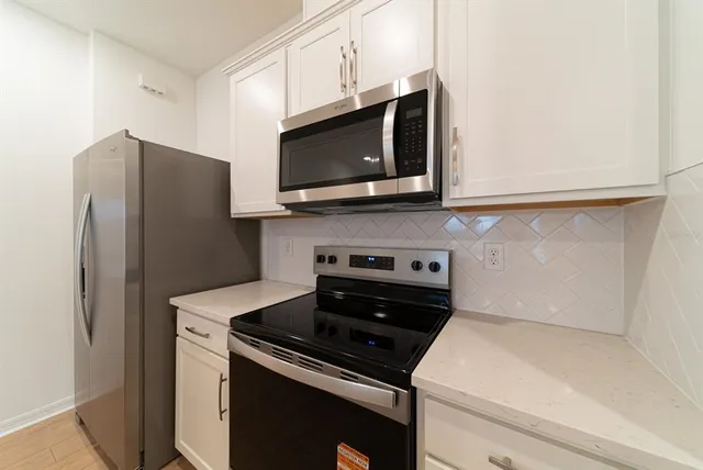 a kitchen with stainless steel appliances a stove microwave and refrigerator