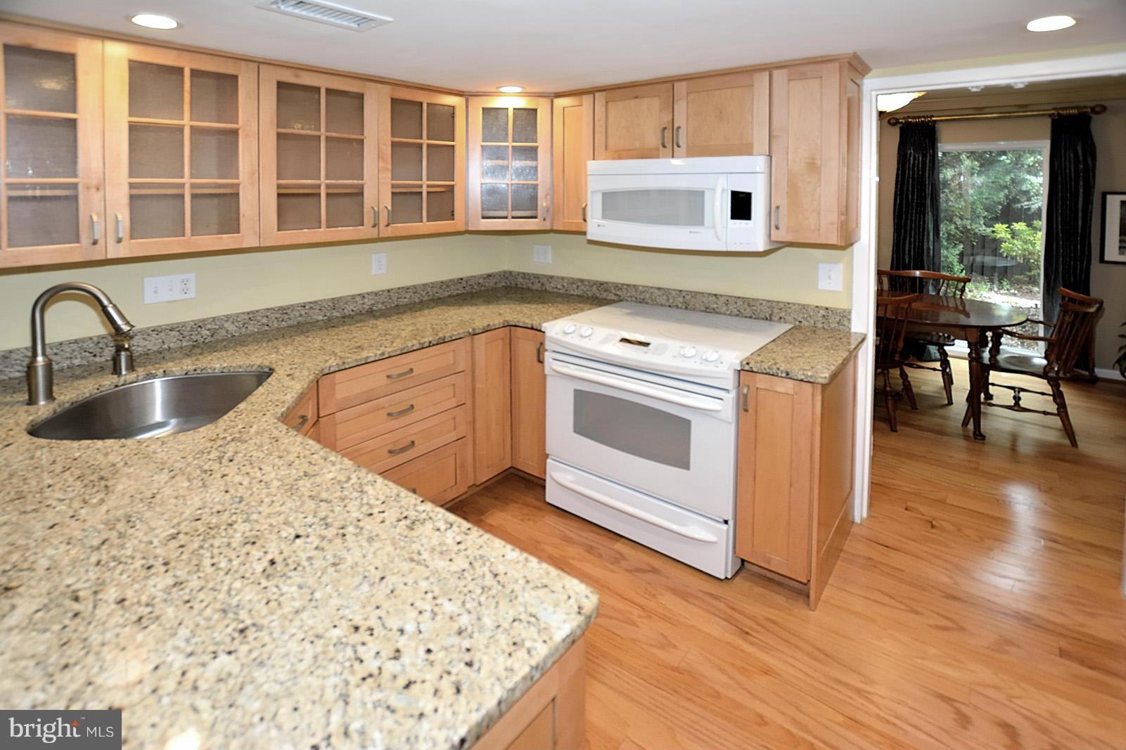 1769 Ivy Oak Square Reston, VA 20190 - Photo 2 of 24 a kitchen with stainless steel appliances granite countertop a sink stove and wooden floor