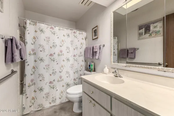 a spacious bedroom with a bed and a chandelier