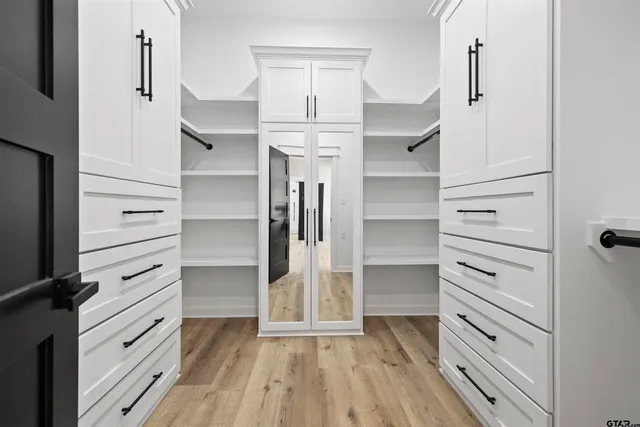 a view of walk in closet with empty racks