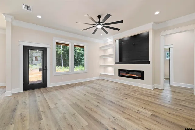 a view of a livingroom with a flat screen tv wooden floor and a ceiling fan