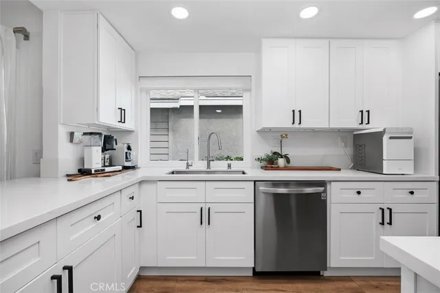 a kitchen with white cabinets and appliances