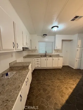 a kitchen with stainless steel appliances granite countertop a sink and cabinets