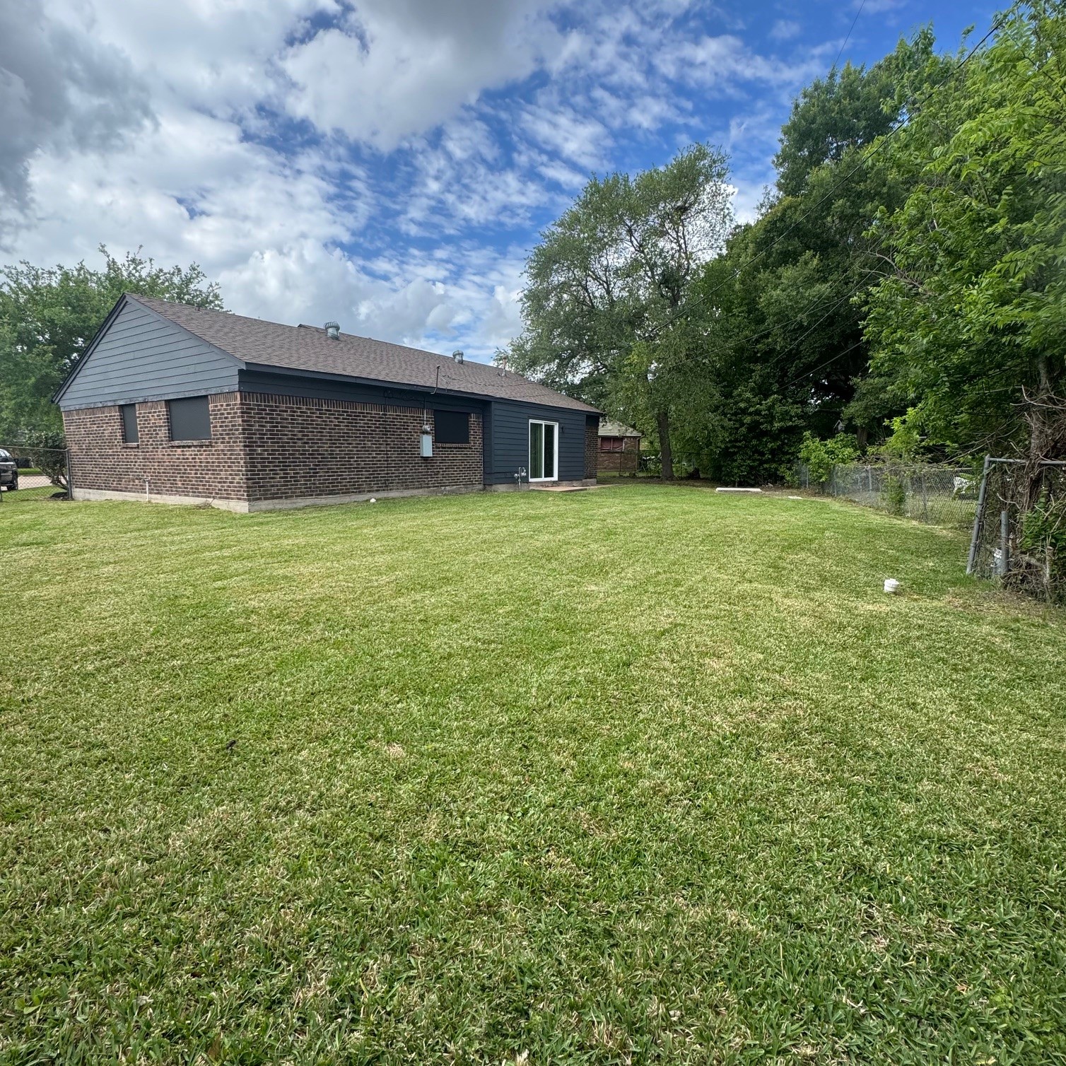 11803 Edgar Street Houston, TX 77047 - Photo 13 of 14 a house is sitting in middle of the green field
