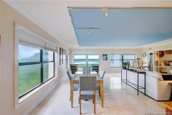 a dining room with furniture and a floor to ceiling window