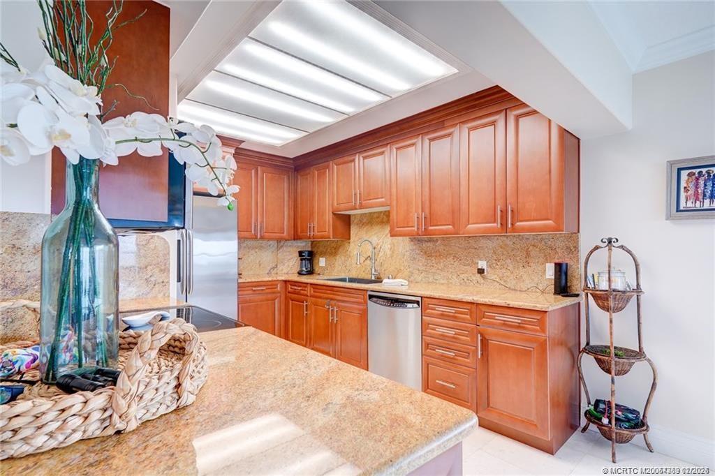 1289 Northeast Ocean Boulevard, Unit 6 Stuart, FL 34996 - Photo 15 of 55 a kitchen with stainless steel appliances granite countertop a sink dishwasher a stove a refrigerator and cabinets with wooden floor