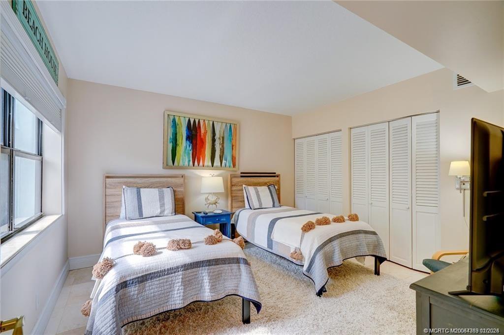 1289 Northeast Ocean Boulevard, Unit 6 Stuart, FL 34996 - Photo 27 of 55 a bedroom with two beds and a flat screen tv
