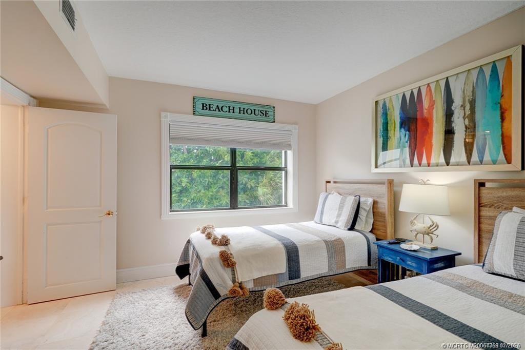 1289 Northeast Ocean Boulevard, Unit 6 Stuart, FL 34996 - Photo 28 of 55 a bedroom with two beds and a window