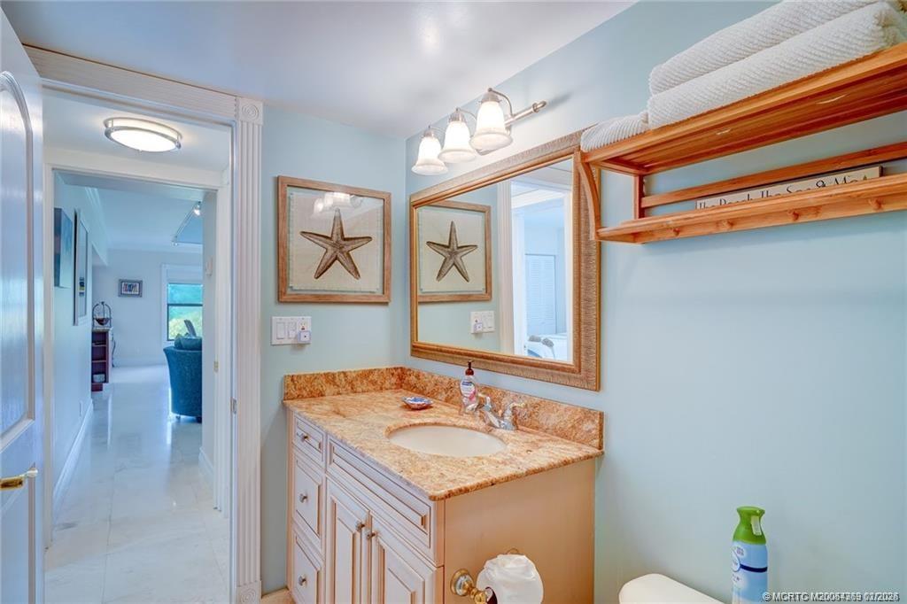 1289 Northeast Ocean Boulevard, Unit 6 Stuart, FL 34996 - Photo 31 of 55 a en suite bathroom with a granite countertop sink and a mirror